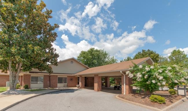 a building with a driveway and trees